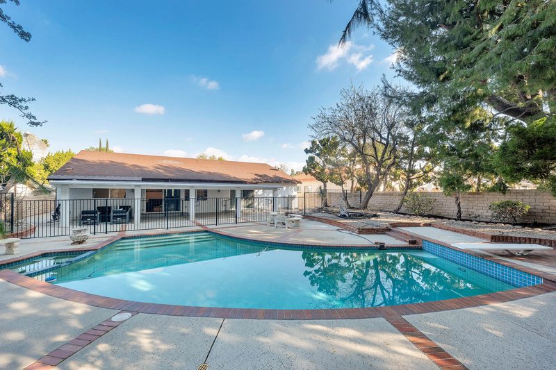 Fenced backyard pool and garden behind the single-story Aurora Lemarsh home in Chatsworth