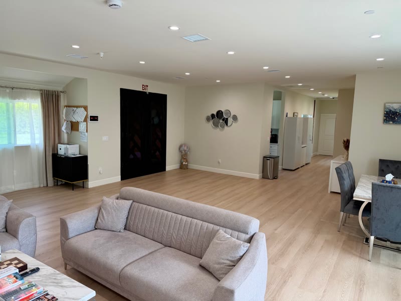 Bright living room and dining area at Aurora Raymer senior living home in Sherwood Forest