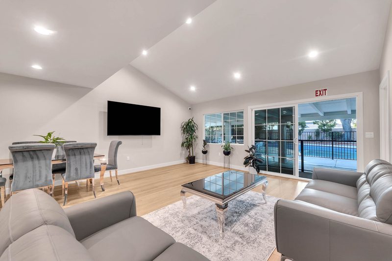 Bright, high-ceiling living room with comfortable sofas and dining table at Aurora Lemarsh in Chatsworth