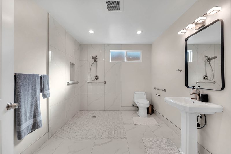 Accessible roll-in shower with grab bars and pedestal sink at Aurora Lemarsh in Chatsworth
