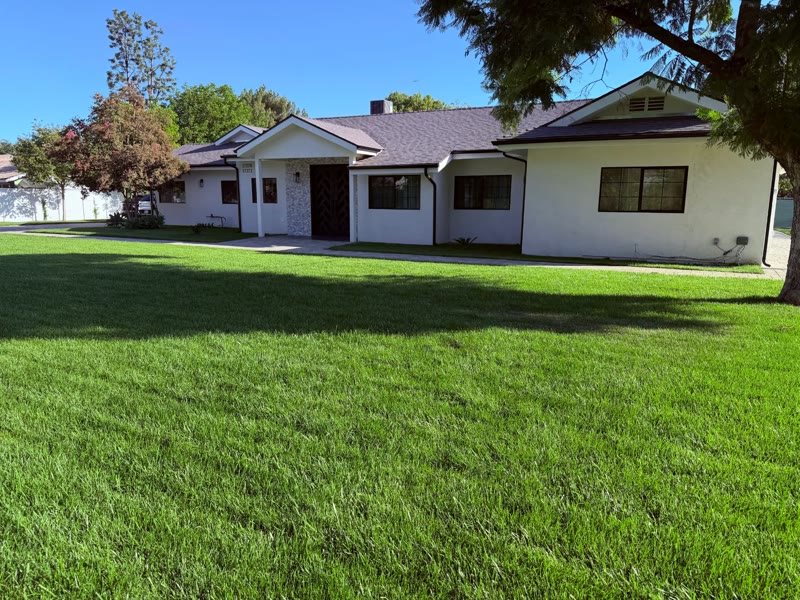 Front lawn and single-story exterior of Aurora Raymer senior living home in Sherwood Forest