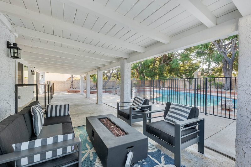 Shaded covered patio with cozy seating and outdoor fire table at Aurora Lemarsh in Chatsworth
